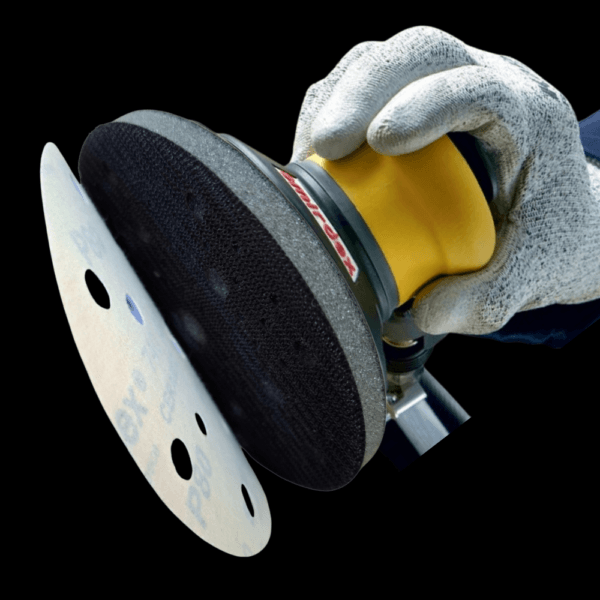 Imagine cu o protecție pad SMIRDEX atașată unui șlefuitor orbital, utilizată pentru lucrări de șlefuire și finisare.